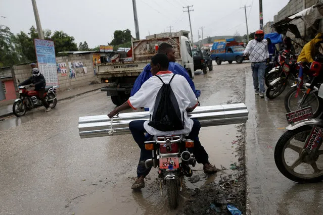 Men carry metal sheets on a motorcycle while Hurricane Matthew approaches Port-au-Prince, Haiti, October 3, 2016. (Photo by Carlos Garcia Rawlins/Reuters)