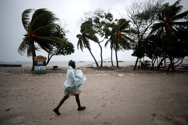 A woman protects herself from rain as Hurricane Matthew approaches in Les Cayes, Haiti, October 3, 2016. (Photo by Andres Martinez Casares/Reuters)