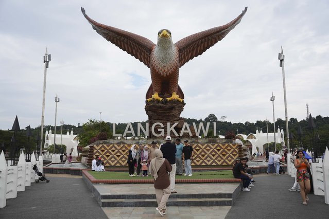 Tourists take pictures with a landmark eagle statue in Langkawi Island, Malaysia, on Saturday, January 18, 2025. (Photo by Azneal Ishak/AP Photo)