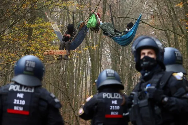 Police officers are seen as demonstrators lie in hammocks hanging from trees during a protest against the extension of the A49 motorway, in a forest near Stadtallendorf, Germany, November 11, 2020. (Photo by Kai Pfaffenbach/Reuters)