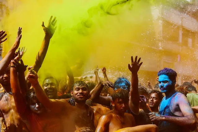 Revellers daubed in colours dance as they celebrate Holi, the Hindu spring festival of colours, in Prayagraj on March 8, 2023. (Photo by Sanjay Kanojia/AFP Photo)