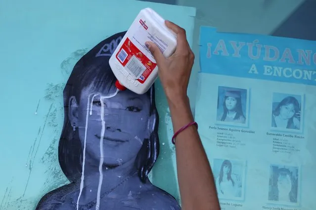 A woman pours glue on a photograph of missing woman Nancy Navarro as it is placed on a window of the Special Prosecutor for Women Victims of Crime Gender office, during a demonstration in Ciudad Juarez, Mexico, November 6, 2015. Mothers of femicide victims and missing women staged a protest to mark the 14th anniversary of the discovery of the bodies of eight women killed in a cotton field, local media reported. (Photo by Jose Luis Gonzalez/Reuters)