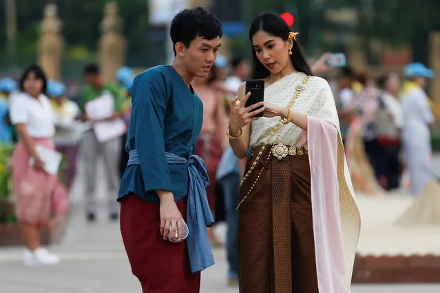 People dressed in traditional costumes look at a mobile phone at the Royal Plaza, as interest for historical clothing rises within the country, in Bangkok, Thailand April 6, 2018. (Photo by Soe Zeya Tun/Reuters)