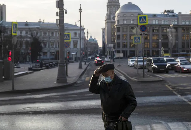 A man wearing a face mask to protect against coronavirus walks along a street in Moscow, Russia, Wednesday, December 2, 2020. Russia has registered a record number of coronavirus deaths for a second straight day. (Photo by Pavel Golovkin/AP Photo)