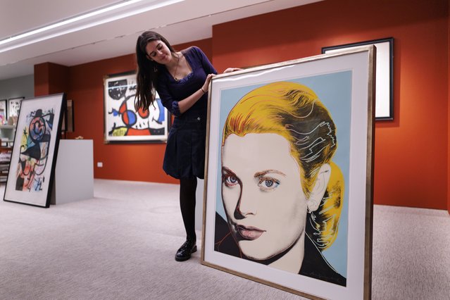 A gallery assistant poses with an artwork titled “Grace Kelly” by US artist Andy Warhol during a photocall for the upcoming Shapero Modern gallery exhibition, which will be displayed at the Frieze Masters annual art fair in London, Britain, 08 October 2025. Frieze Masters runs from 15 to 19 October 2025 in Regent's Park, London. (Photo by Tolga Akmen/EPA)