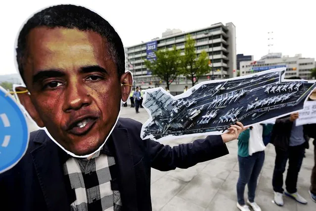 A protester wearing a mask of President Barack Obamaholds a model piece of a U.S. aircraft carrier during a rally denouncing the joint naval drills between the United States and South Korea, near the U.S. Embassy in Seoul, on May 9, 2013. Nuclear-powered U.S. carriers routinely come to South Korea around this time of year as part of drills aimed at enhancing naval cooperation, South Korean Defense Ministry spokesman Kim Min-seok said Monday in a briefing. But Seoul wouldn't discuss whether any U.S. nuclear-capable assets were participating in this week's drills, and U.S. military officials declined to comment on operations. (Photo by Lee Jin-man/Associated Press)