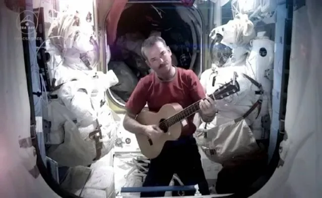 Handout grab taken from YouTube of Commander Chris Hadfield who has said goodbye to life on the International Space Station by making a cover version of David Bowie's Space Oddity. Issue date: Monday May 13, 2013. (Photo by Commander Chris Hadfield/YouTube/PA Wire)