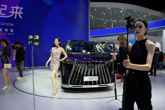 People film around the GAC Trumpchi E9 at the Auto Shanghai show, in Shanghai, China on April 18, 2023. (Photo by Aly Song/Reuters)