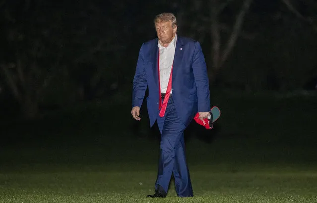President Donald Trump walks on the South Lawn of the White House in Washington, early Sunday, June 21, 2020, after stepping off Marine One as he returns from a campaign rally in Tulsa, Okla. (Photo by Patrick Semansky/AP Photo)