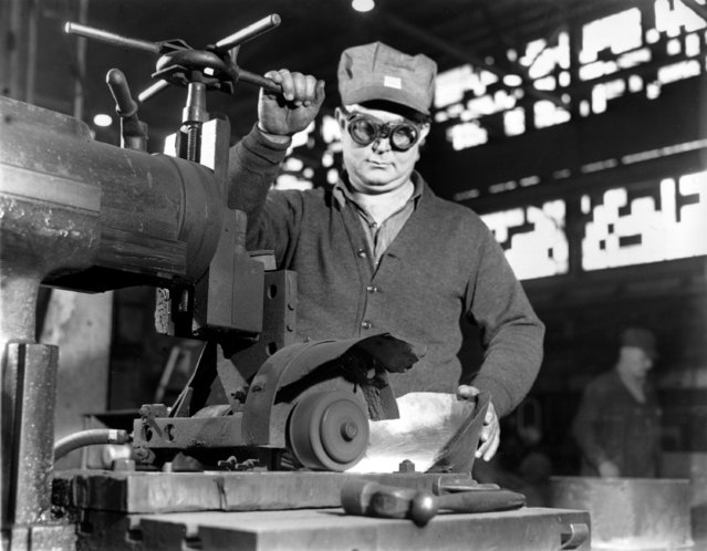 Charles E. Gaskins works at an emery wheel in the Norfolk Navy Yard as he helps turn out fighting ships for the war effort in Portsmouth, Va., on February 28, 1942. (Photo by AP Photo)