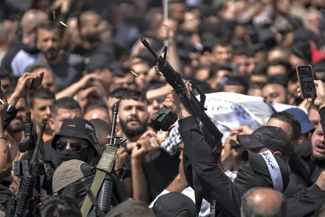Palestinian militants from the Lions' Den armed group shoot in the air at the funeral procession of three comrades who were killed by Israeli forces earlier this year, Odai Shami, Jihad Shami and Mohammad Dabik, in the West Bank city of Nablus, Saturday, May 6, 2023. The killing of Zuhair al-Ghaleeth last month, the first slaying of a suspected Israeli intelligence collaborator in the West Bank in nearly two decades, has laid bare the weakness of the Palestinian Authority and the strains that a recent surge in violence with Israel is beginning to exert within Palestinian communities. (Photo by Nasser Nasser/AP Photo)