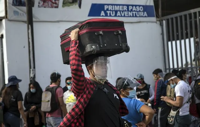 A passenger, wearing protective face gear amid the new coronavirus pandemic, arrives at a long-distance bus terminal, in Lima, Peru, Saturday, January 30, 2021. Hundreds of people are traveling to their provinces of origin before a strict two-week quarantine begins Sunday in various regions of the country as a measure to curve the spread of COVID-19. (Photo by Rodrigo Abd/AP Photo)