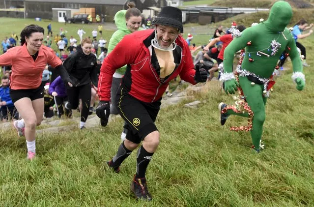 Competitors take part in the Christmas Really Wild Mud Run on a 4.6 miles course across undulating farm land at Celtic Camping, St David's, Pembrokeshire, Wales, December 12, 2015. (Photo by Rebecca Naden/Reuters)