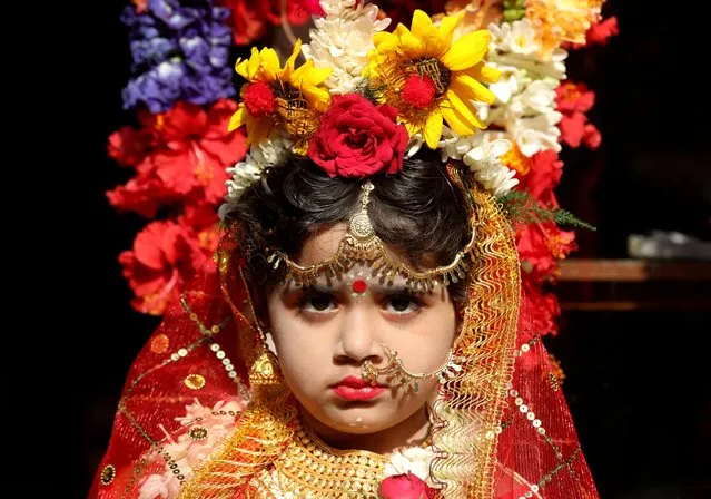 A girl dressed as a Kumari waits to attend the rituals to celebrate the Hindu festival of Navratri outside the Adyapeath temple on the outskirts of Kolkata, India, April 10, 2022. (Photo by Rupak De Chowdhuri/Reuters)