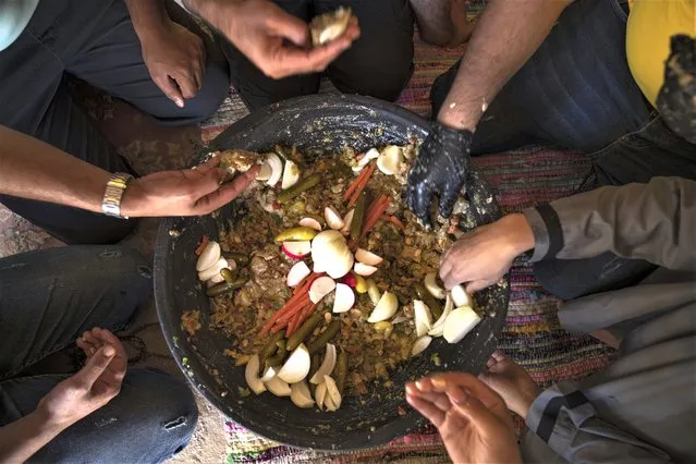 Palestinians eat “Lasima”, a dish that is popular in the southern Gaza Strip but shunned in its north, at a garden in Khuzaa, Gaza Strip, Saturday, May 20, 2023. Locals call it “watermelon salad”. But this seasonal delicacy is far from the sweet, refreshing taste the name evokes. (Photo by Fatima Shbair/AP Photo)