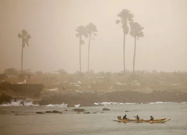 Fishermen are pictured on their pirogue as dust carried by winds from the Sahara Desert shrouds Dakar, Senegal on February 18, 2021. (Photo by Zohra Bensemra/Reuters)