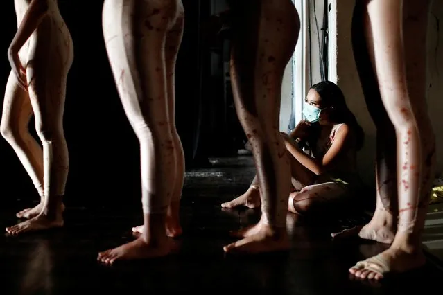 A dancer wearing a protective mask to curb the spread of the coronavirus disease (COVID-19), sits during a virtual dance performance titled “The Story of Man: In Search of A New Ideal” by Namarina Youth Dance, at the Jakarta Art Building, Indonesia, February 21, 2021. (Photo by Willy Kurniawan/Reuters)