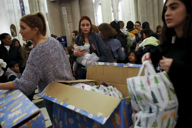 People wait in line during a distribution of free toys for low-income families at Almudena Cathedral in Madrid, Spain, December 22, 2015. (Photo by Susana Vera/Reuters)