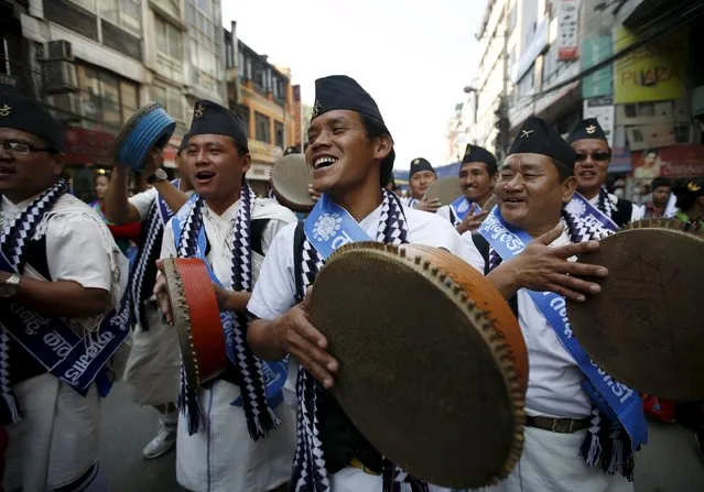 Gurung men wearing traditional costumes sing and dance as they play traditional musical instruments while taking part in a New Year parade in Kathmandu, Nepal December 30, 2015.. (Photo by Navesh Chitrakar/Reuters)
