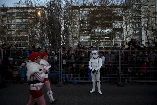 A performer dressed as a Star Wars Stormtrooper looks at other performers before the start of the traditional Epiphany parade in Madrid, Spain, January 5, 2016. (Photo by Susana Vera/Reuters)