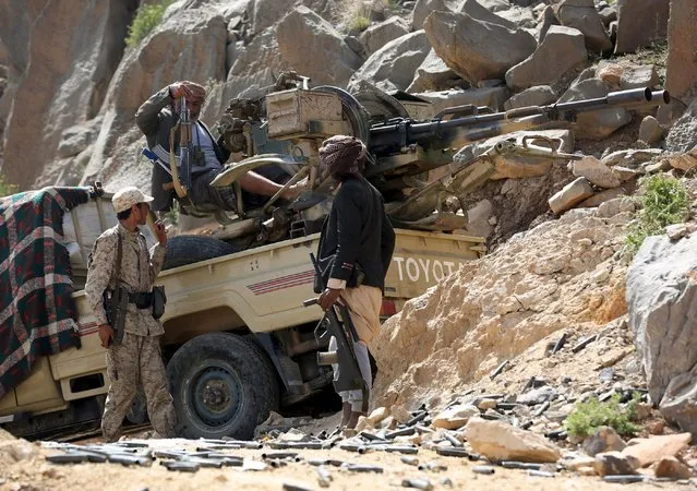 A soldier and tribal fighters loyal to Yemen's government are pictured at their position in Al Khurais village of Nihm district east of the capital Sanaa January 11, 2016. (Photo by Ali Owidha/Reuters)