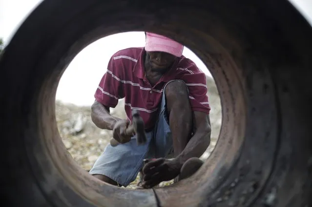 Sony Lonrisme cuts a discarded oil barrel in Noailles, an artisan's village in Croix de Bouquets, outskirts of Port-au-Prince, Haiti February 13, 2015. (Photo by Andres Martinez Casares/Reuters)