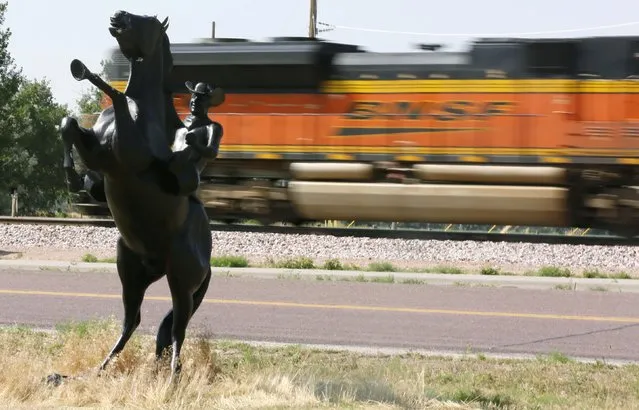 A Burlington Northern Santa Fe (BNSF) train rolls by a statue of the state symbol of the state of Wyoming, a bucking bronco, in Ft. Laramie, Wyoming in this July 15, 2014, file photo. A potential merger of Canadian Pacific Railway Ltd and Norfolk Southern would make it hard for No. 3 U.S. railroad CSX Corp to survive alone and ratchet up pressure for more industry consolidation, the chairman of No. 2 U.S. railroad BNSF said on January 14, 2016. (Photo by Rick Wilking/Reuters)