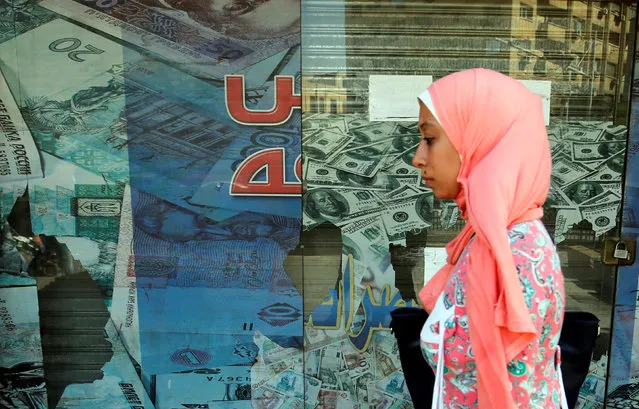 A woman walks past a money exchange bureau showing images of the U.S dollar with Egyptian pound and other foreign currency in Cairo, Egypt, October 12, 2016. (Photo by Amr Abdallah Dalsh/Reuters)