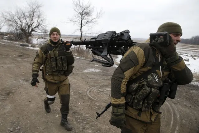 Fighters with the separatist self-proclaimed Donetsk People's Republic army carry a machine gun at a check point on the road from the town of Vuhlehirsk to Debaltseve, February 20, 2015.
 REUTERS/Baz Ratner  (UKRAINE - Tags: POLITICS CIVIL UNREST CONFLICT MILITARY)