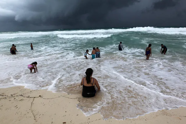 People swim in the turbulent sea at a beach in Cancun, Quintana Roo, Mexico, 07 October 2018. Tropical depression 14 that was moving to Florida through the Gulf of Mexico has turned into tropical storm Michael, the National Hurricane Center (NHC) reported. (Photo by Alonso Cupul/EPA/EFE)