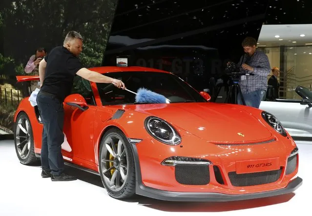 An employee dusts off the new Porsche 911 GT3 RS is seen during the second press day ahead of the 85th International Motor Show in Geneva March 4, 2015.  REUTERS/Arnd Wiegmann   