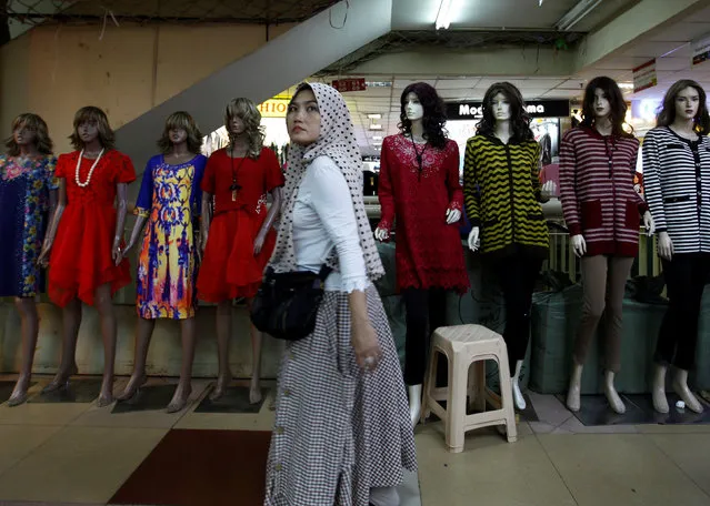 A woman walks in front of a mannequin at Tanah Abang textiles market in Jakarta, Indonesia, January 10, 2017. (Photo by Fatima El-Kareem/Reuters)