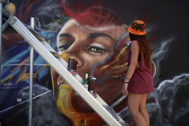 Liliana Demitri, a graffiti artist from Italy, paints a mural as part of the Meeting of Styles graffiti festival in Kosovo's capital Pristina, Kosovo on July 28, 2023. (Photo by Fatos Bytyci/Reuters)