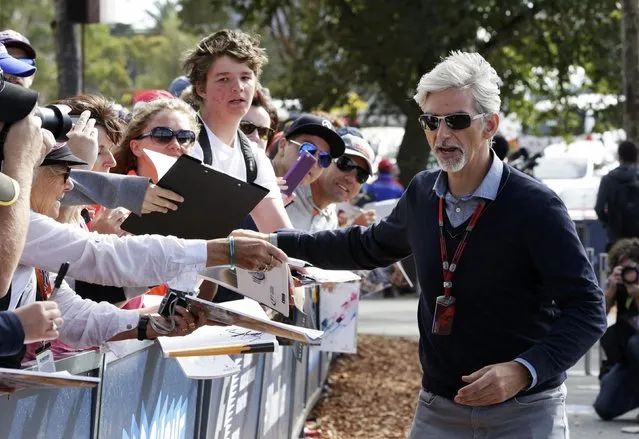 Former Formula One driver Damon Hill of Britain (R) arrives at the first practice session of the Australian F1 Grand Prix at the Albert Park circuit in Melbourne March 13, 2015.    REUTERS/Mark Dadswell