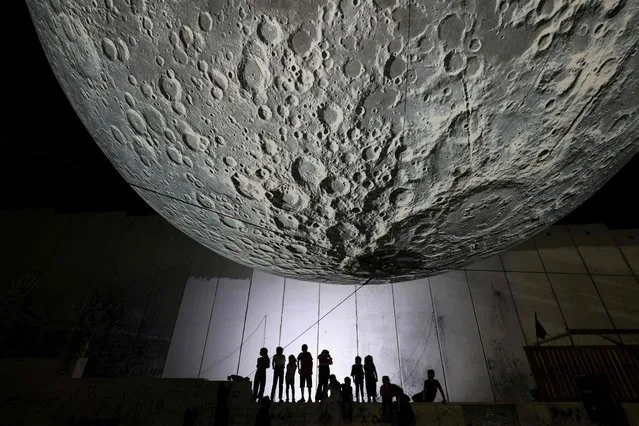 UK artist Luke Jerram's touring artwork entitled “the Museum of the Moon” is displayed at the Aida camp for Palestinian refugees near Bethlehem in the occupied West Bank, next to Israel's controversial separation barrier on September 16, 2023. (Photo by Hazem Bader/AFP Photo)