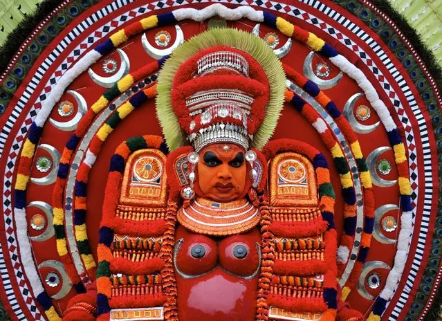 An artist dressed as the Hindu goddess Raktha Chamunda waits to perform during the Theyyam ritual in Somwarpet town in the southern Indian state of Karnataka March 17, 2015. Theyyam is a form of worship and is celebrated mostly in southern parts of the country. (Photo by Abhishek N. Chinnappa/Reuters)