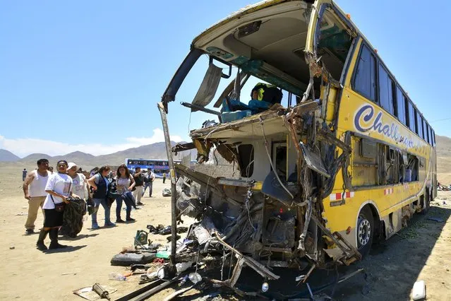 People stand next debris of a bus after a multiple-vehicle accident at kilometer 315 of the Panamericana Norte highway near the coastal town of Huarmey, March 23, 2015. At least 34 people were killed and 70 injured in north-central Peru after a bus swerved into another bus in the oncoming lane in a multiple-vehicle accident, authorities said on Monday. Another bus and a refrigerator truck slammed into the buses soon after, said emergency coordinator Oscar Gonzalez. (Photo by Toshiro Villanueva/Reuters)