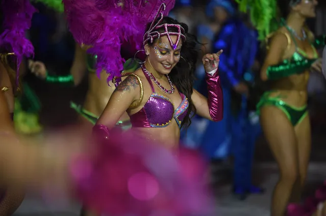 Dancers and drummers forming a group known as “comparsa”, competes by playing and dancing to the rhythm of the traditional “candombe” music, in Montevideo on February 4, 2016 during the first day of the “Llamadas”, only one of events that make up Uruguay's carnival – the world's longest. (Photo by Pablo Porciuncula/AFP Photo)