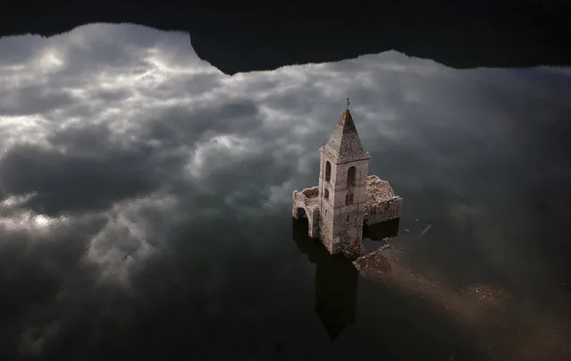 A church and remains of an ancient village which are usually covered by water are seen inside the reservoir of Sau, in Vilanova de Sau, Catalonia, Spain, Thursday, January 11, 2018. The reservoir, built in the early 1960s submerging a village called San Roman de Sau and its 11th century romanesque church, is so low on water that the ruins of buildings are re-emerging. (Photo by Emilio Morenatti/AP Photo)