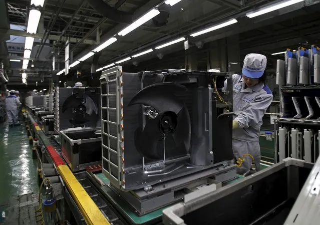 An employee of Daikin Industries Ltd works the production line of outdoor air conditioning units at the company's Kusatsu factory in Shiga prefecture, western Japan March 20, 2015. As Japan heads into the season of peak demand for room air-conditioners, Daikin managers have been tasked with figuring out how to boost output by some 20 percent at the 45-year-old Kusatsu plant that six years ago the company had almost given up on as unprofitable. (Photo by Yuya Shino/Reuters)