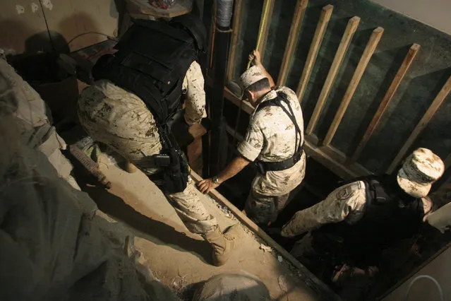 Soldiers inspect the entrance of a cross border tunnel at a warehouse in Tijuana, July 12, 2012. (Photo by Jorge Duenes/Reuters)