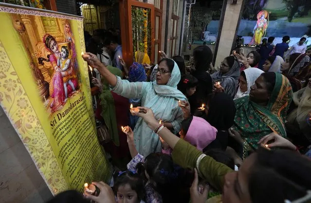 Hindu women hold clay-lamp during a ceremony to celebrate Diwali, the festival of lights, at Somi Narin temple in Karachi, Pakistan, Sunday, November 12, 2023. (Photo by Fareed Khan/AP Photo)
