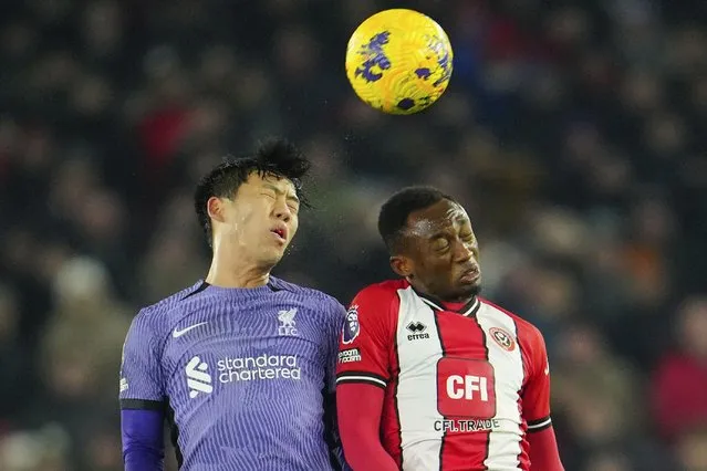 Liverpool's Wataru Endo, left, jumps to head the ball with Sheffield United's Benie Traore during the English Premier League soccer match between Sheffield United and Liverpool at Bramall Lane in Sheffield, England, Wednesday, December 6, 2023. (Photo by Jon Super/AP Photo)