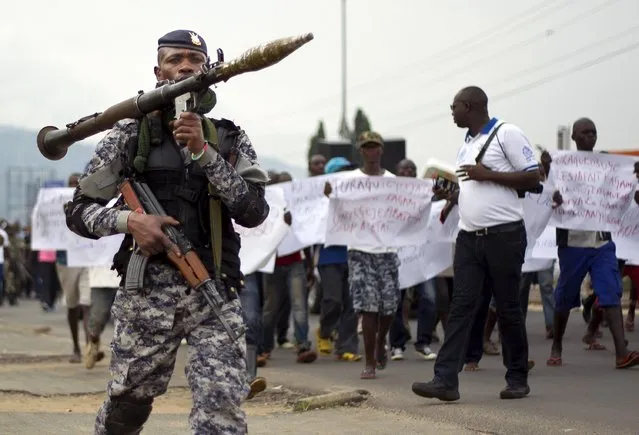 A Burundian soldier walks infront of residents during a demonstration against the Rwandan government in Burundi's capital Bujumbura, February 20, 2016. (Photo by Evrard Ngendakumana/Reuters)