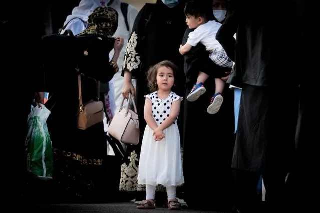 A young girl queues up to board a bus after disembarking an Air Belgium evacuation flight arriving from Afghanistan at Melsbroek Military Airport, in Melsbroek, Belgium, 24 August 2021. The plane carried more than 200 Belgian citizens and Afghans who had helped the Belgian mission in Afghanistan. (Photo by Stephanie Lecocq/EPA/EFE)