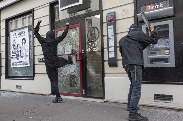 A bank is vandalised during a demonstration against the rising cost of living and climate inaction on October 16, 2022 in Paris, France. Organisers said some 140,000 attended, police said they expected crowds of 30,000. (Photo by Sam Tarling/Getty Images)