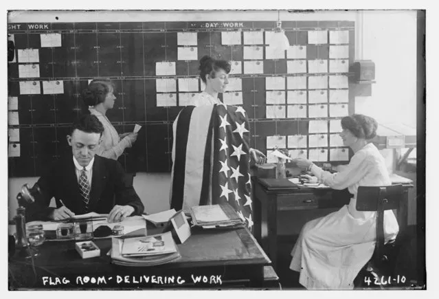 A man and women, one holding an American flag, work in an office at the Brooklyn Navy Yard, Brooklyn, New York, July 7, 1917, in this Library of Congress handout photo. (Photo by Reuters/Bain Collection/Library of Congress)