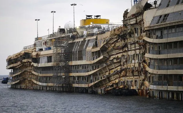 The cruise liner Costa Concordia is seen during the “parbuckling” operation outside Giglio harbour January 11, 2014. Thirty massive tanks filled with air will lift the hulk of the Costa Concordia off the seabed in June so it can be towed away from the Italian island of Giglio where it capsized two years ago, officials said on Friday. (Photo by Max Rossi/Reuters)
