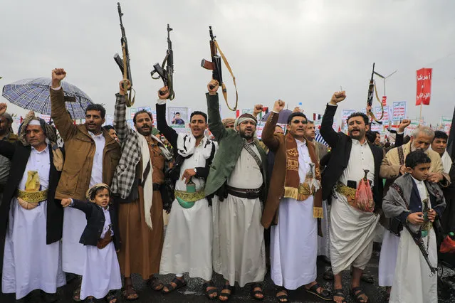 People lift rifles and placards as they chant during an anti-Israel and anti-US rally in the Huthi-controlled capital Sanaa on January 19, 2024, protesting the US designation of Yemen's Huthi rebels as “terrorists”, after a series of attacks on Red Sea shipping amid ongoing battles between Israel and the militant Hamas group in Gaza. (Photo by Mohammed Huwais/AFP Photo)