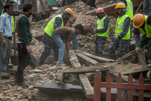 Emergency workers and bystanders clear debris while searching for survivors under a collapsed temple in Basantapur Durbar Square following an earthquake on April 25, 2015 in Kathmandu, Nepal. (Photo by Omar Havana/Getty Images)